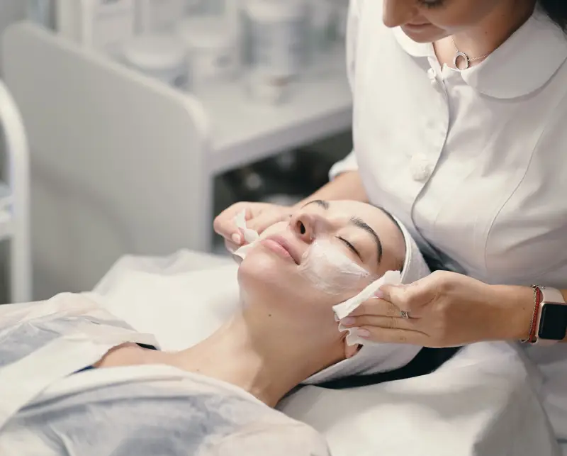 services 03 web new A professional wearing a white coat applies a product to a client's shoulder in a well-equipped treatment room.